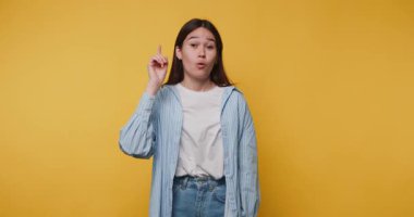 Genç bir kadının görüntüsü, sarı arka planda parlak sarı bir arka planda duruyor.