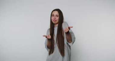 Genç bir kadının neşeli bir şekilde parmaklarını ve gülümsemelerini gösteren görüntüler ışık arka planında eğlenceli ve etkileşimli bir ruh taşıyor.