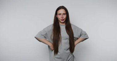 Genç bir kadının görüntüsü, elleri açık arka planda durarak kafa karışıklığı gösteriyor.