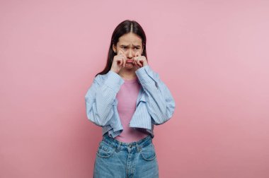 Kız pembe bir arkaplana karşı duruyor, sıcak bir ifadeyle duygularını ifade ediyor. Gençlik havasını yakalayan günlük giysiler giyiyor. Bağlantı kurulabilir duygularını geliştiriyor..