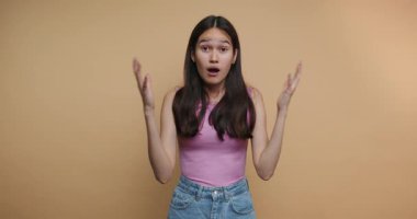 Bir kadın coşkusunu canlı el hareketleri ve yüz ifadeleri kullanarak paylaşır. Parlak bir stüdyoda geçiyor. Mesajını iletirken heyecanını belli ediyor..