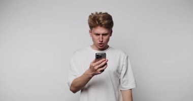 Beyaz gömlek giymiş genç bir adam, basit, açık gri bir odada telefonuyla meşgul olurken çeşitli ifadeler sergiliyor. Kaydırdıkça tepkileri yavaş yavaş değişiyor..