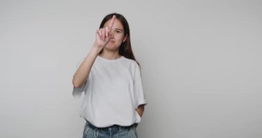 Genç bireyin yükseltilmiş işaret parmağıyla çekilmiş görüntüleri, beyaz arka planda önemli bir noktayı veya talebi işaret ediyor