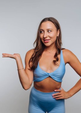 Mavi giysili kadın arka planda poz veriyor..