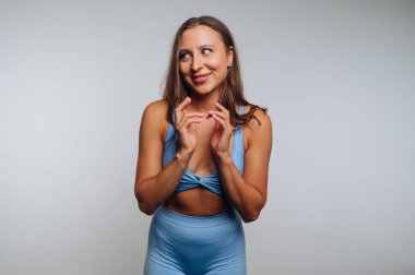 Mavi takım elbiseli kadın arka planda şakacı poz veriyor..