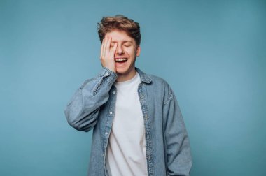 Mavi arka planda el ele gülen genç adam..