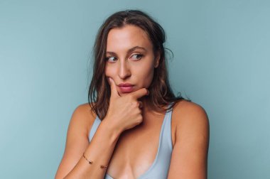 Mavi arka planda düşünceli bir kadın..