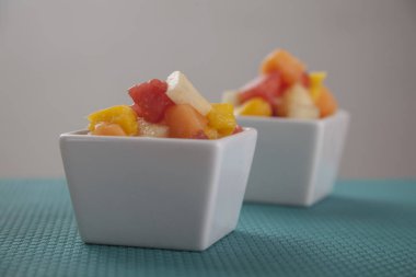 Meyve salatası karışımı kavun, muz, karpuz, portakal ve ananas küçük porselen kase, kahvaltı veya sağlıklı snack, kilo verme kavramı