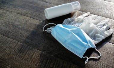 Coronavirus önleme seyahati. Ahşap arka planda koruyucu maske, eldiven ve el dezenfektanı..
