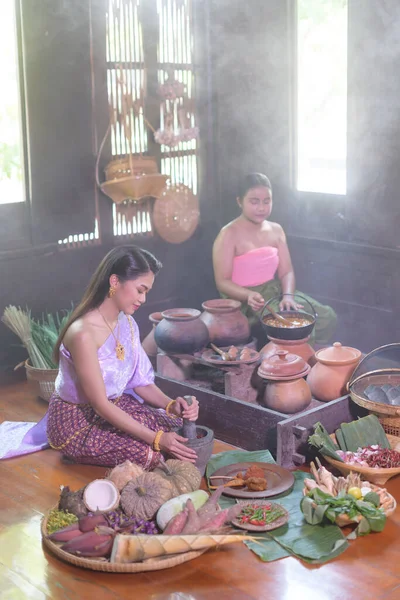 Thai woman cooking in retro Thai dress