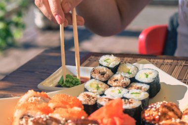 Kadın Japonya sopa ile Sokak kafede Suşi yiyor