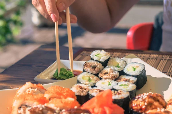 Kadın Japonya sopa ile Sokak kafede Suşi yiyor