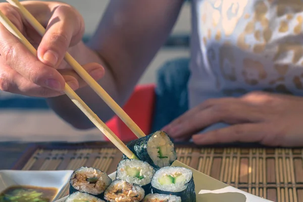 Kadın Japonya sopa ile Sokak kafede Suşi yiyor