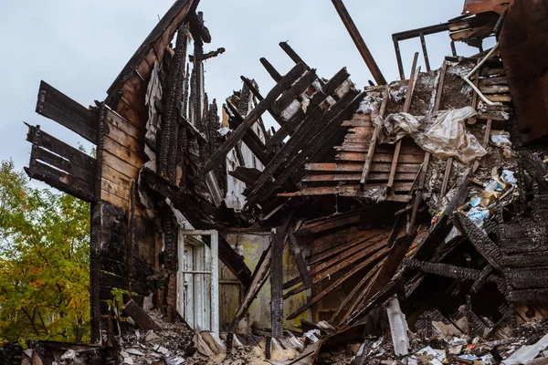 the old wooden burned-down house with furniture a view from inside