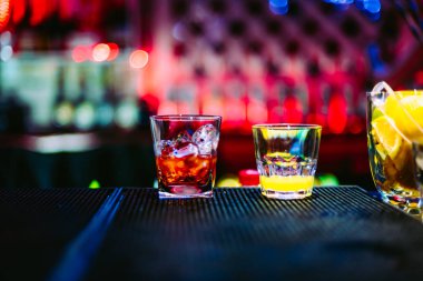 bir raf üzerinde kokteyller ile iki bardak gece kulübü ile parlak bokeh barda