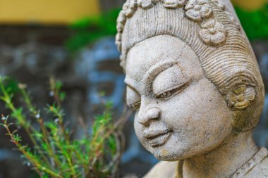 sessiz bir bahçe içinde bir taş Asya Tanrı figürü