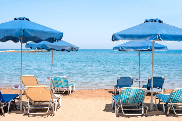 View of the transparent blue sea from coast with blue umbrellas