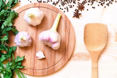 Ahşap plaka üzerinde üç adet taze sarımsak yüksek nokta görünümü