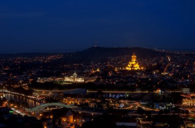 Hükümete ve Holy Trinity Katedrali'ne bakan gece Tiflis'in panoramik manzarası