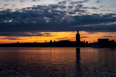 Alacakaranlıkta körfezden Stockholm merkezinin silhuettes görüntüle