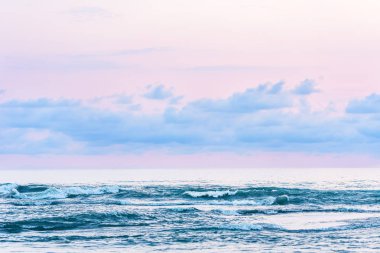 Pembe gün batımı ışığı ile mavi deniz görünümü