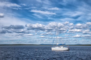 Güneşli bir günde, Boreal Ormanı 'nda Rus bayrağı taşıyan mavi Pasifik gölü ve pek çok güzel bulut.