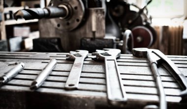 Demir bir masa yüzeyinde duran eski metal aletler.