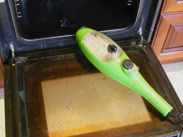 Cleaning kitchen hob and oven with a steam cleaner, view before when oven is dirty and fatty