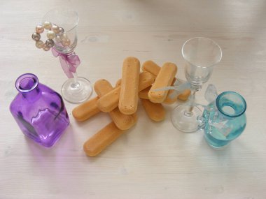 Violet ile birçok Savoiardi çerezleri kapatmak ve mavi deniz mavisi şişe ve cam bir vintage beyaz tablo.