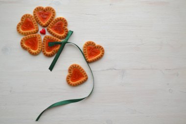 Kırmızı reçel ile kalp şeklinde çerez çiçek sembolü, ahşap masa üzerinde boşaltmak. Aşk Sevgililer kavramı. Kahvaltı masası. Tatil Partisi, Doğum günü. Bisküvi tatlı çerez arka plan.