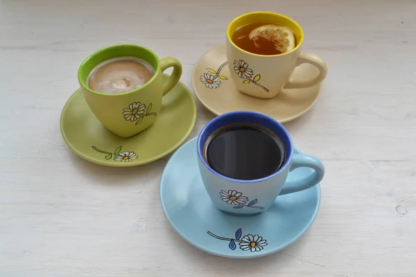 Set with different colorful cups of coffee espresso, cappuccino and tea.