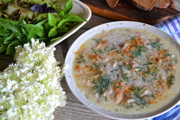 Russian rural cuisine: meat aspic on white plate with herbs on shabby table
