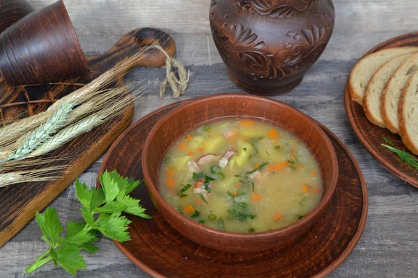 新鮮な緑の葉 ニンニクで飾られた素朴なボウルにスプリットエンドウ豆のスープ — ストック写真