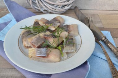 Eski plaka ve rustik eski shabby masada otlar ile Matjes Ringa Balığı