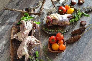 Koyu eskiz masada ahşap rustik tahta üzerinde lezzetli çiğ woodcock ve keklik