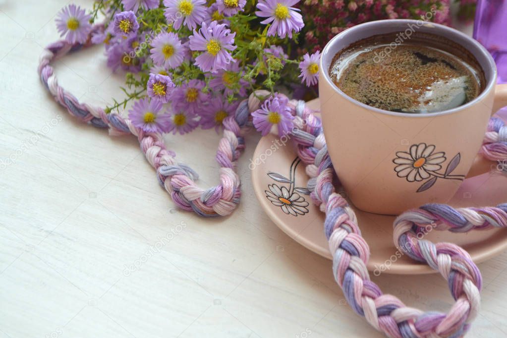 Cup of coffee and flowers on wooden table background. with copy space vintage style in violet and white