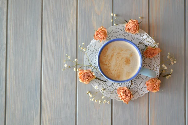 Morning coffee or cappuccino and dry rose flowers on blue vintage table top view — Stock Photo, Image