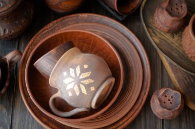 Kırsal el yapımı seramik kil kahverengi terracotta bardaklar, tabaklar, kaseler. Üst görünüm.