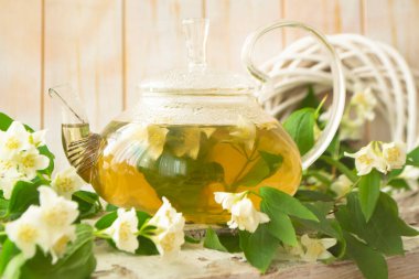 Sıcak çay ve yasemin çiçekli cam çaydanlık. Kapat.