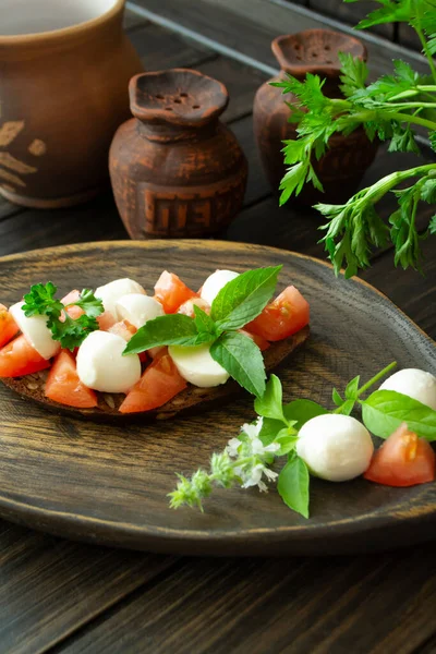 Bruschetta Červenými Rajčaty Mozzarella Sýrem Bazalkou Starém Venkovském Tmavém Stole — Stock fotografie