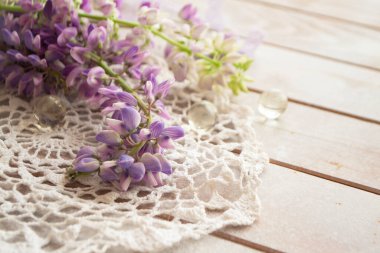 Kırsal beyaz ahşap arka planda hoş lupin ve klasik dantel ışıkta, çiçekli tebrik kartı.