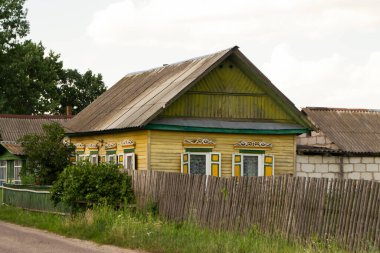 Belarus 'ta oyulmuş pencereleri ve dekorasyonu olan otantik, pejmürde ahşap bir ev.