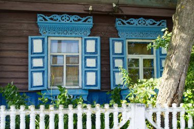 Mavi şekilli ahşap çerçeve pencereler. Dikey şeritler ve pastiller şeklinde farklı pencere çerçeveleri. Belarus Köyü