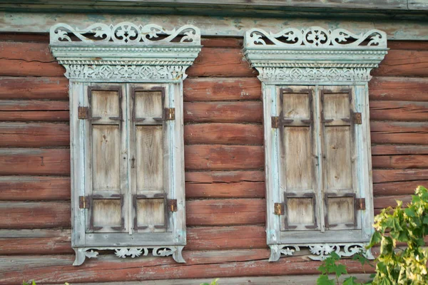 Carved wooden window with shutters. Old wooden window shutters on a log wall. Traditional wood carving, Belarus. Close up