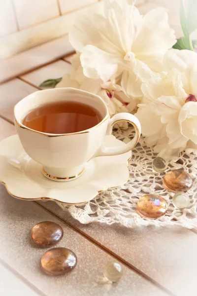 Buquê de peônias, chá em copo elegante branco, foto em cores suaves. Bom dia e tenha um bom conceito de dia. — Fotografia de Stock