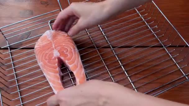 Female hands cooking trout fish. Female hands putting slices of raw salmon. Fish cooking process. Beautiful shooting of food — Stock Video