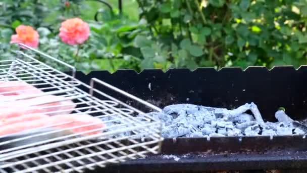 男性の手はバーベキューの格子で魚をひっくり返します。村のライフスタイル。グリルの上のサーモンの赤い魚。トラウトステーキのグリル — ストック動画