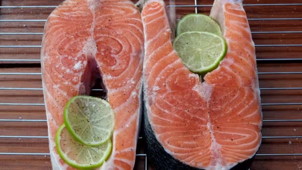 Raw salmon steak is sprinkled with pink Himalayan salt. Red fish cooking. Seafood. Fish trout cooking process. Beautiful shooting of food — Stock Video