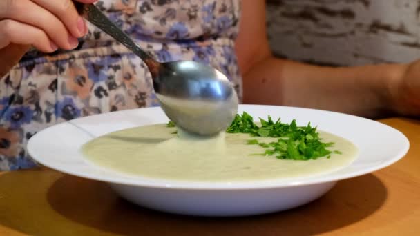 Donna che mangia zuppa vegetariana con appetito. Degustazione solo preparare la zuppa in cucina — Video Stock