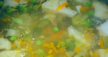 Sebze veya minestrone çorbası soba üzerinde metal bir tencerede pişirin. Çorba havuç, biber, otlar ve patates sıcak tencerede, yakın. Ev yapımı yemek. Sağlıklı vejetaryen veya yağsız gıda kavramı